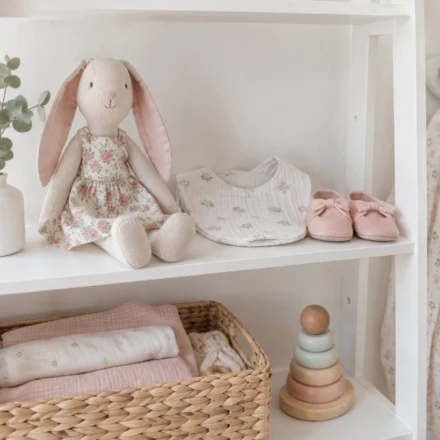 Handmade fabric bunny, bib and baby shoes on a nursery shelf - baby sewing patterns